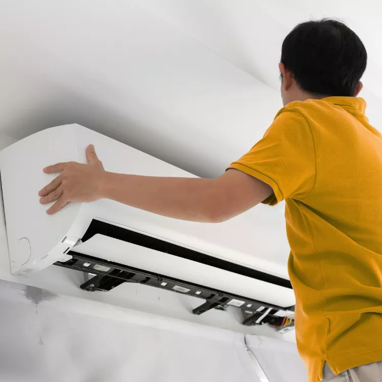 professional ac installation technician installing indoor unit